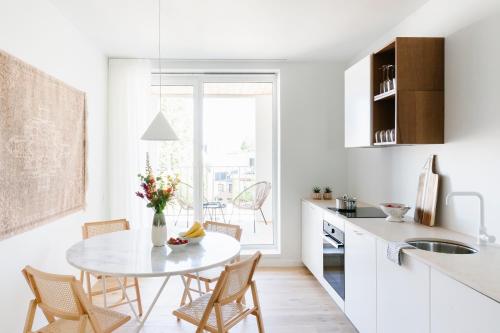 a white kitchen with a table and chairs and a window at High-end flats at South area in Antwerp