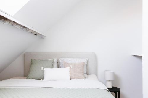 1 dormitorio con 1 cama con sábanas y almohadas blancas en High-end flats at South area, en Amberes