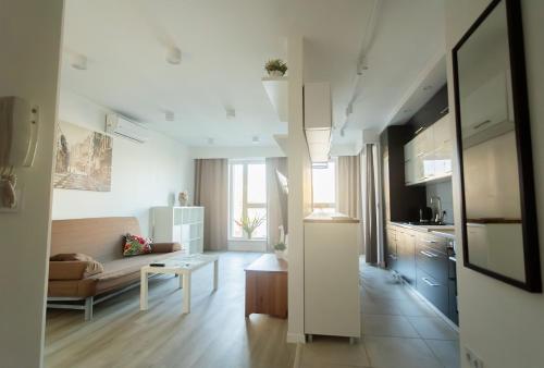 sala de estar amplia con sofá y cocina en Warsaw Apartment, en Varsovia