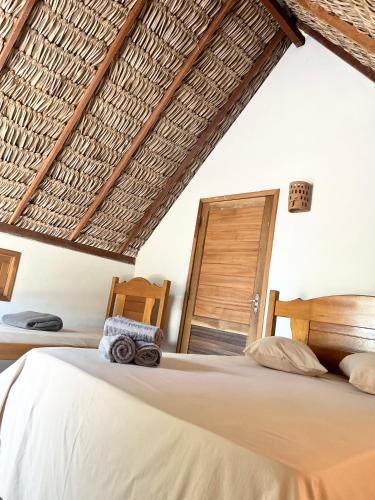 a bedroom with a bed and a wooden chair at Hausatins in Atins