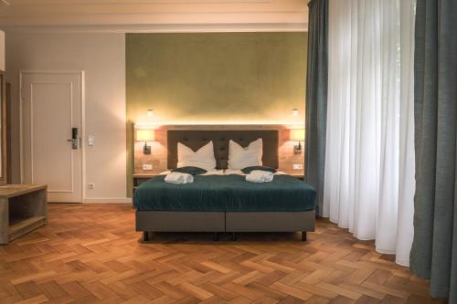 - une chambre avec un lit doté de draps verts et d'oreillers blancs dans l'établissement VillaWie, à Rheda-Wiedenbrück