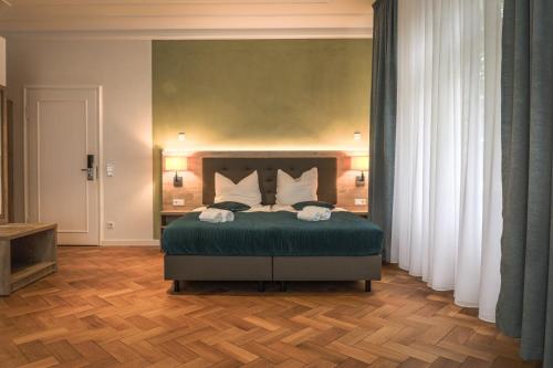 a bedroom with a bed with green sheets and white pillows at VillaWie in Rheda-Wiedenbrück