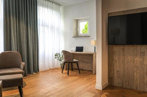 ein Wohnzimmer mit einem TV, einem Tisch und Stühlen in der Unterkunft VillaWie in Rheda-Wiedenbrück
