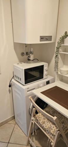 a microwave sitting on top of a counter with a chair at TOP 06 in Fohnsdorf