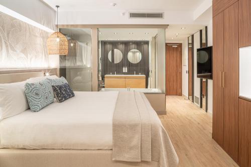 a bedroom with a large bed and a television at Sir Anthony in Playa de las Americas