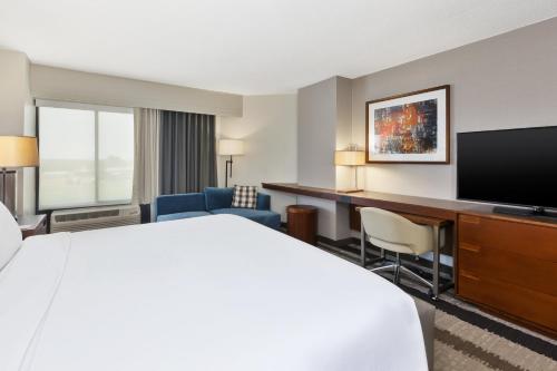 a hotel room with a bed and a desk and a television at Crowne Plaza Dulles Airport by IHG in Herndon