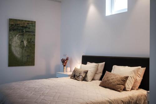 a bedroom with a large bed with white pillows at De verloren hoek in Aarschot