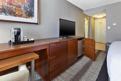 a hotel room with a desk with a television at Crowne Plaza Dulles Airport by IHG in Herndon