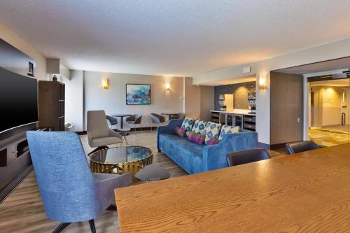 a living room with a blue couch and a table at Crowne Plaza Dulles Airport by IHG in Herndon