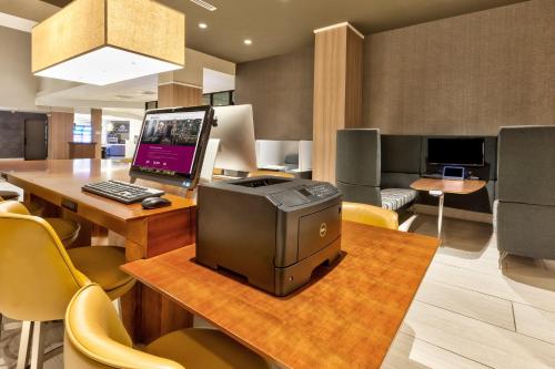 a room with a desk with a computer on a table at Crowne Plaza Dulles Airport by IHG in Herndon