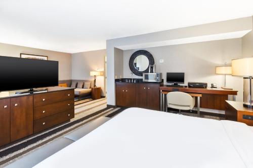 a hotel room with a bed and a flat screen tv at Crowne Plaza Dulles Airport by IHG in Herndon