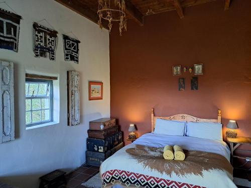 a bedroom with a bed with two logs on it at Wolverfontein Karoo Cottages in Ladismith