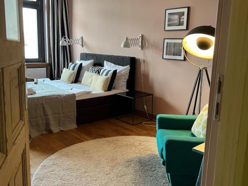 a bedroom with a bed and a green chair at Brilliant Apartments in Berlin