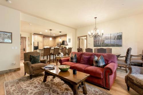 B107 Beaver Creek Landing condo في بيفر كريك: غرفة معيشة مع أريكة حمراء وكراسي
