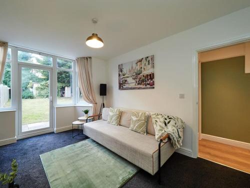 uma sala de estar com um sofá e algumas janelas em House In Birmingham - Perfect For Contractors - Working Professionals - Driveway - 14 Mins To NEC - 13 Mins to BHX em Birmingham