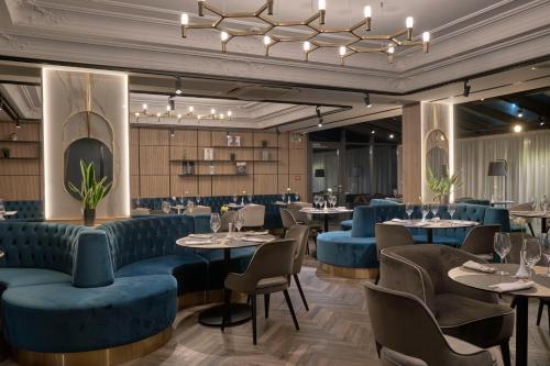 a restaurant with blue seating and tables and chairs at Radisson Hotel Plovdiv in Plovdiv