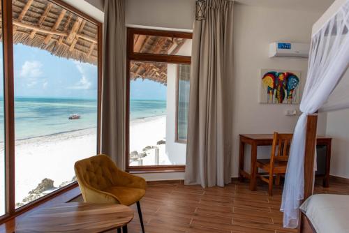a bedroom with a view of the beach at S&S HOTEL in Jambiani