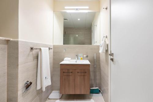 a bathroom with a sink and a mirror at Cozy Studio In Oasis in Al Qurayyah