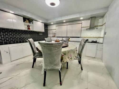 una cucina con tavolo e sedie in una stanza di บ้านนายหัว ก ชุมพร a Ban Tha Samet (1)
