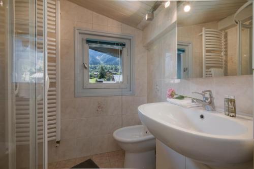 La salle de bains est pourvue d'un lavabo, de toilettes et d'une fenêtre. dans l'établissement Appartement Le Carlaveyron - Happy Rentals, aux Houches