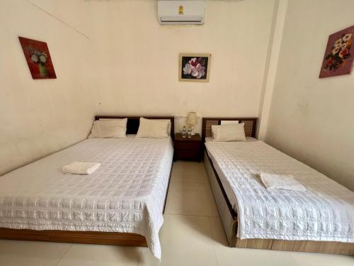 two twin beds in a room with white walls at Vientiane Star Hotel in Vientiane