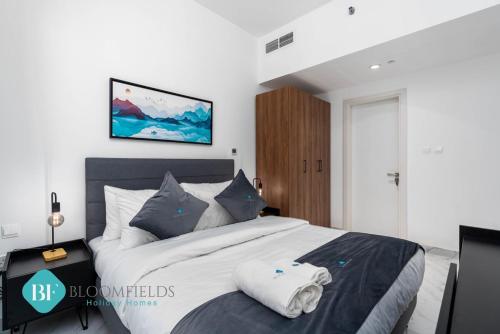 um quarto com uma grande cama branca com almofadas azuis em Deluxe 1 Bedroom In Oasis em Abu Dhabi