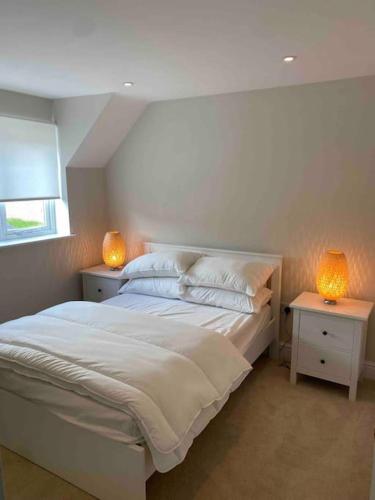 a bedroom with a white bed with two night stands at Cotswold Cottage in Cheltenham