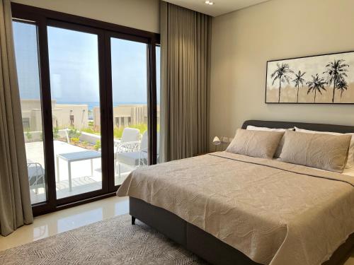 1 dormitorio con cama y vistas a un patio en Escape Villa en As Sīfah