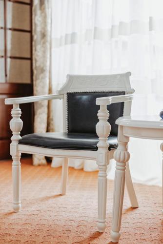 a black chair sitting next to a white table at Complex Turistic Constantin Bucovina in Câmpulung Moldovenesc