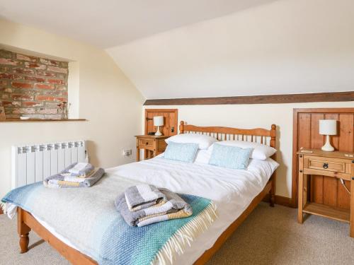 a bedroom with a bed with towels on it at Heron Cottage in Colyton