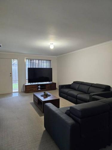 a living room with couches and a flat screen tv at Beach Haven in Rosebud