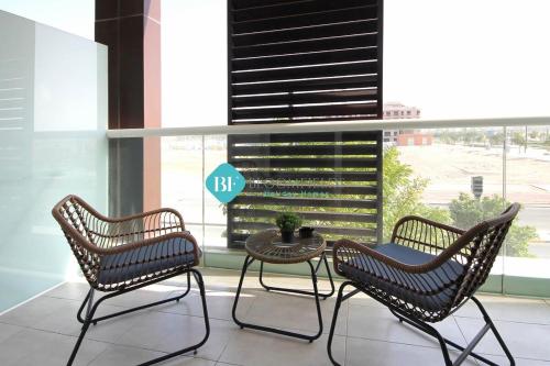 3 Stühle und ein Tisch vor einem großen Fenster in der Unterkunft Furnished Studio With Huge Balcony in Al Qurayyah