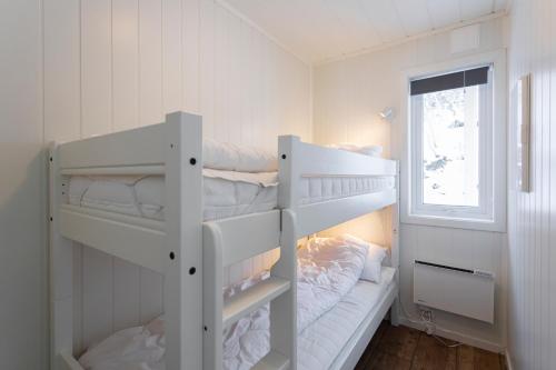 two bunk beds in a white room with a window at Nærøysund Rorbuer AS in Rørvik