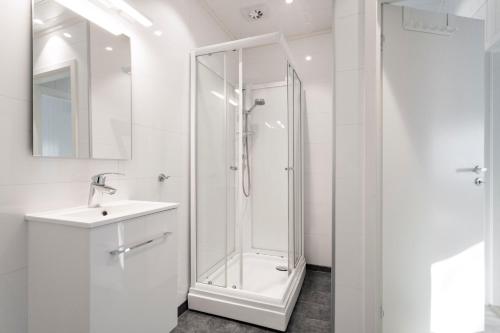 a white bathroom with a shower and a sink at Nærøysund Rorbuer AS in Rørvik