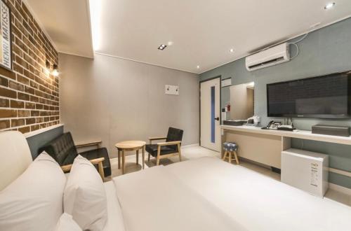 um quarto de hotel com uma cama e uma cozinha em Heimish Hotel em Tongyeong