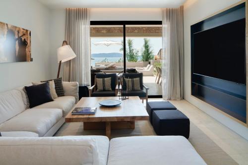 a living room with a large flat screen tv at W Costa Navarino in Pylos