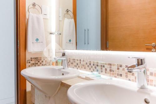 a bathroom with a white sink and a mirror at Golf Course View, Stylish 2 Bedroom in Al Qurayyah