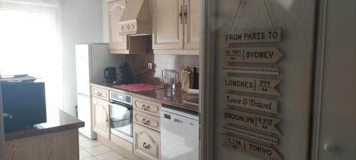 eine Küche mit einem Kühlschrank mit Schildern in der Unterkunft Appartement 3pcs terrasse, calme in Mèze