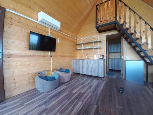 a living room with a tv and a wooden wall at chemi kera Chalet in Makho