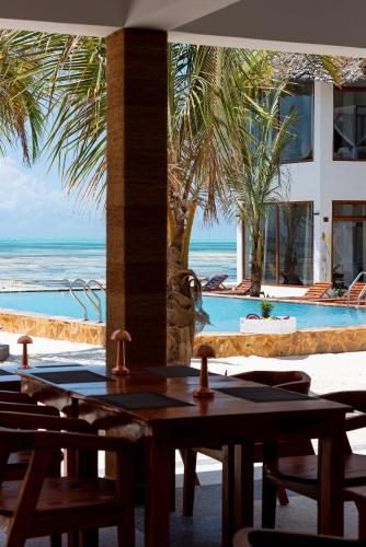a restaurant with a table and a view of the ocean at S&S HOTEL in Jambiani