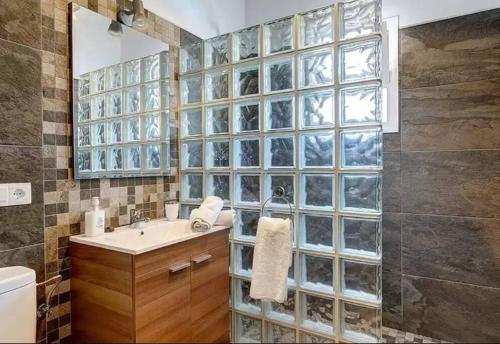 ein Badezimmer mit einem Waschbecken und einer Glaswand in der Unterkunft Villa Antonio in Nerja