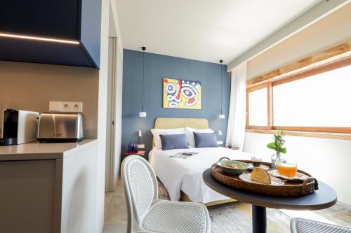 een slaapkamer met een bed en een tafel met een dienblad met eten erop. bij Aspasios Bonjardim Apartments in Porto