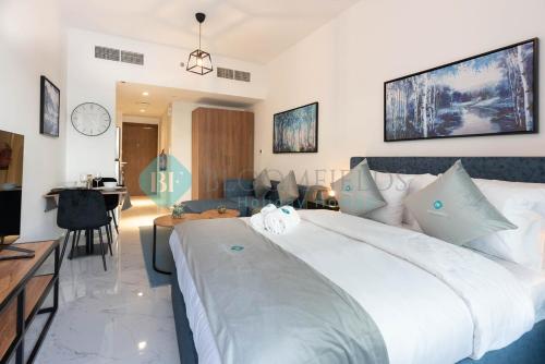 a bedroom with a large white bed and a living room at Lavish Pool View Apartment in Abu Dhabi