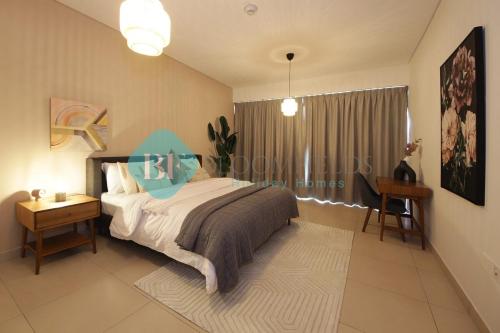 a bedroom with a bed and a table and a window at Luxury 2 Bedroom In Reem Island in Abu Dhabi