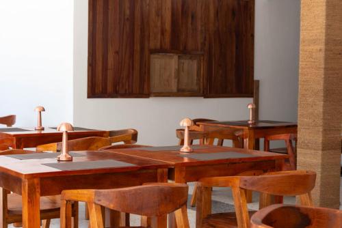 a dining room with wooden tables and chairs at S&S HOTEL in Jambiani