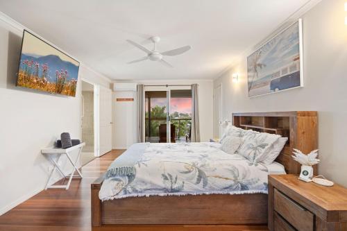 a bedroom with a bed and a ceiling fan at Coco Palms in Hervey Bay