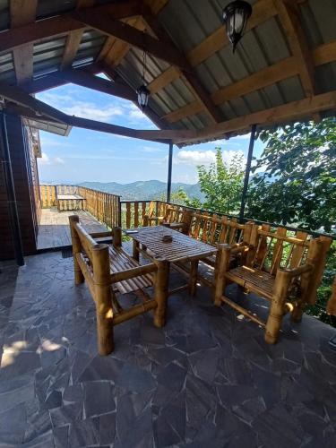 a picnic table and benches on a patio with a view at chemi kera Chalet in Makho