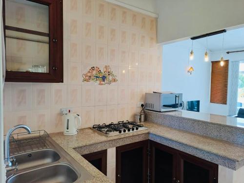 a kitchen with a sink and a stove top oven at Cosy Two Bedroom Apartment in Grand Gaube