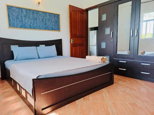 a bedroom with a large bed with blue pillows at Cosy Two Bedroom Apartment in Grand Gaube