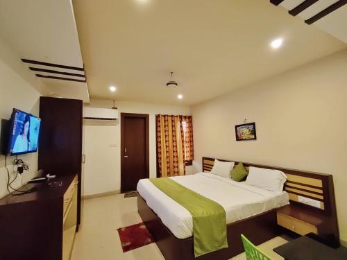 a bedroom with a bed and a flat screen tv at Hotel Jasmin Palace in Angul